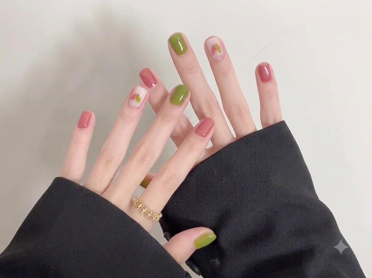 Scatto ravvicinato che evidenzia lintricata nail art doodle creata su una base morbida e chiara su unghie corte.