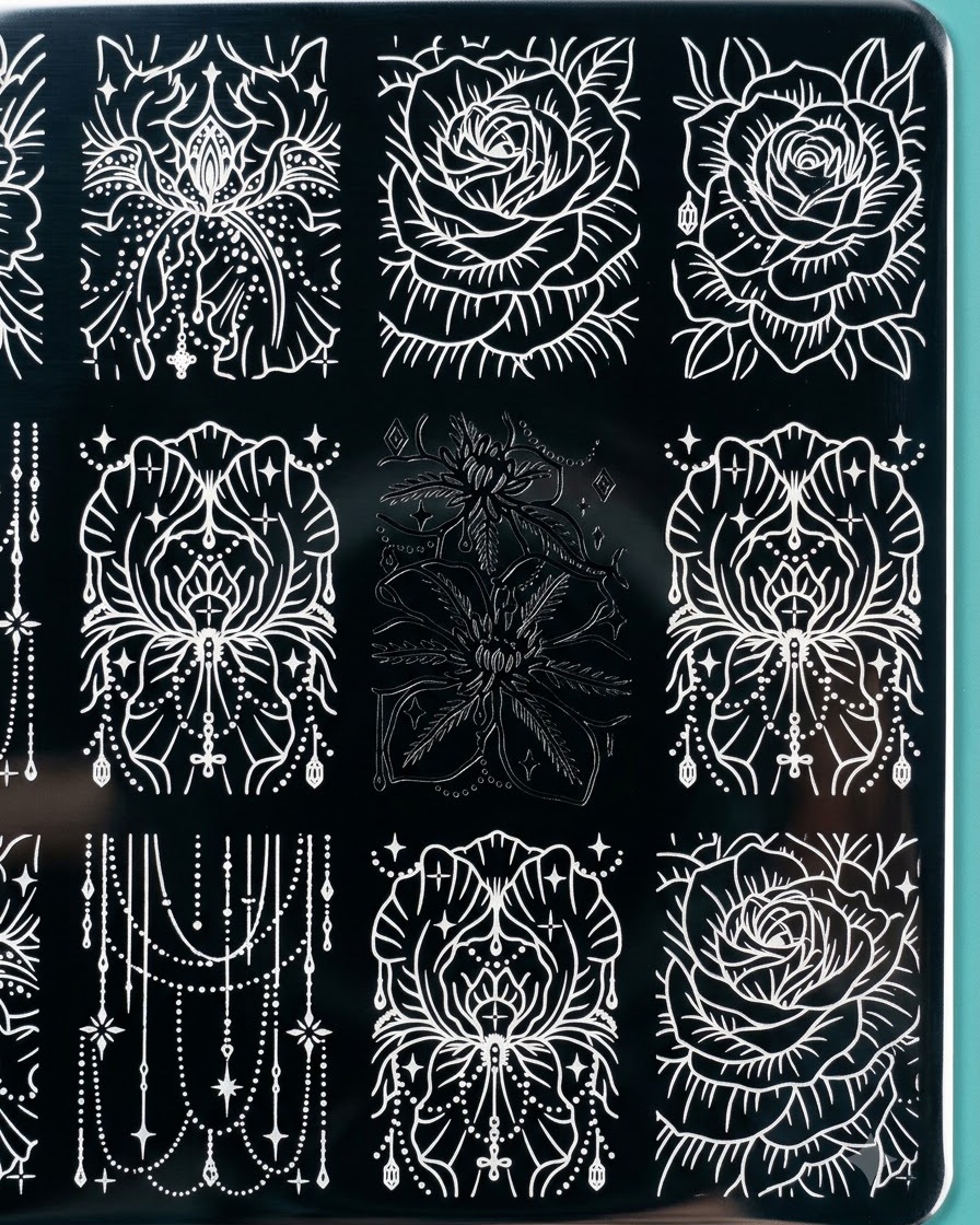 Un timbro in silicone trasparente che solleva unincisione floreale nera dettagliata da una piastra metallica per stamping.