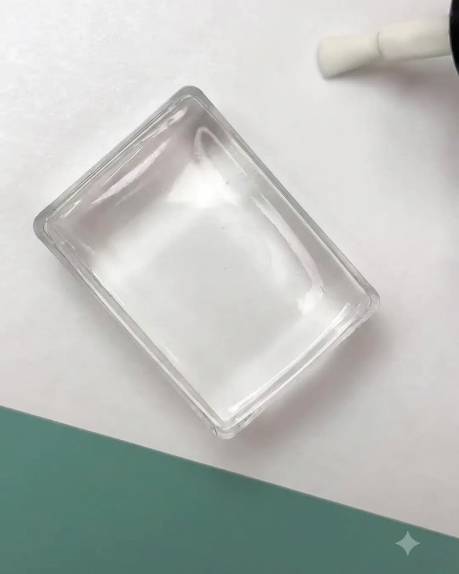 Un timbro in silicone trasparente che preme un design con contorno floreale nero sulla superficie di ununghia preparata.