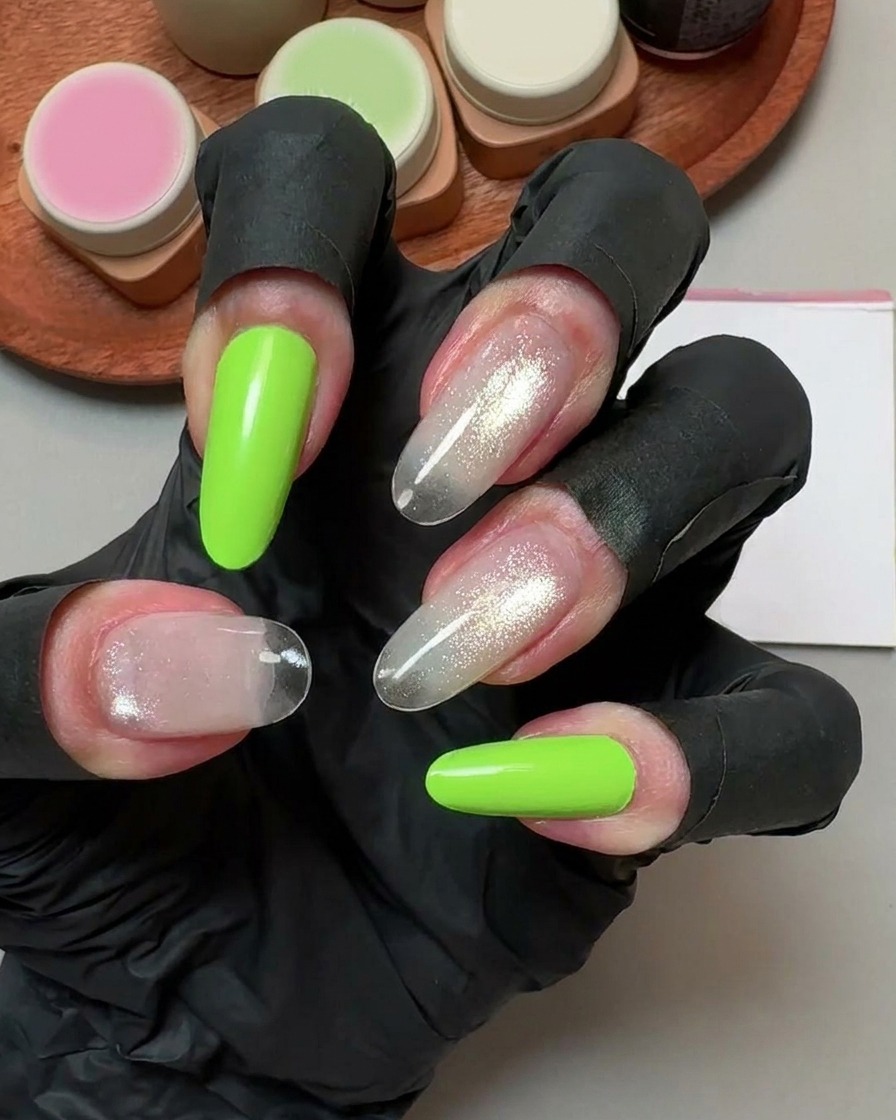 Una mano con guantes negros sosteniendo una almohadilla limpiadora sobre uñas postizas curadas.