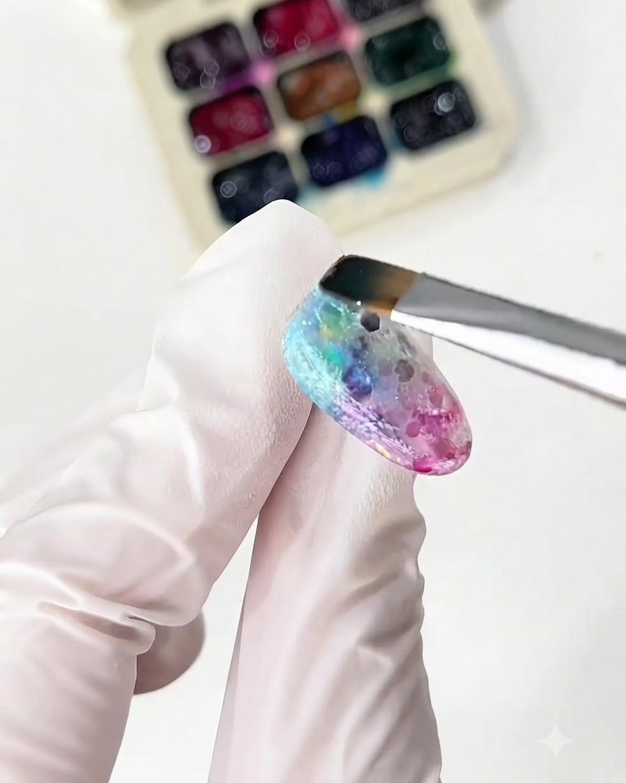 Un pennello sottile applica i glass gel giallo e verde sullunghia.
