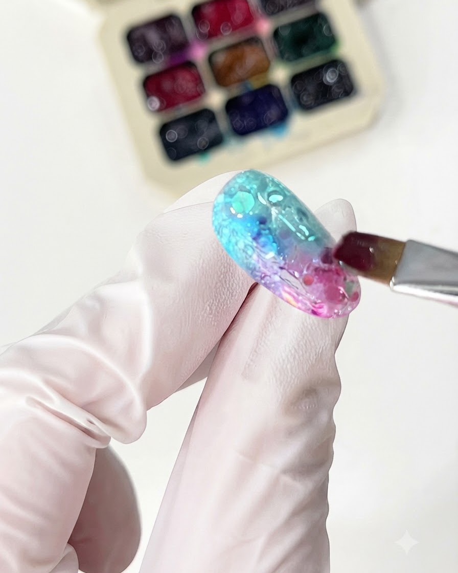 Un pennello sottile applica il glass gel arancione per completare il design della sfumatura.