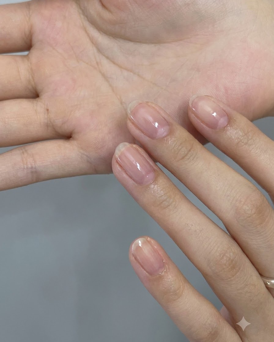 Una vista ravvicinata di una mano che tiene un assortimento di scaglie di glitter olografiche rosa a forma di stella e cuore sul palmo.