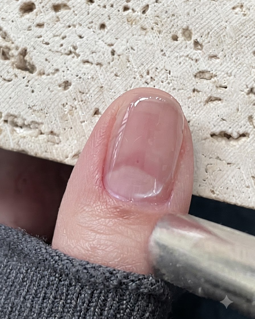 Uno strumento magnetico posizionato vicino a ununghia in gel cat eye lucida per attirare le particelle magnetiche.