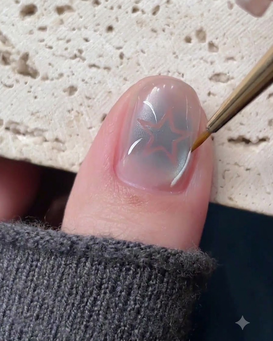 Un pennello liner sottile che disegna delicate linee bianche e argentate attorno a un design per unghie con stella cava.