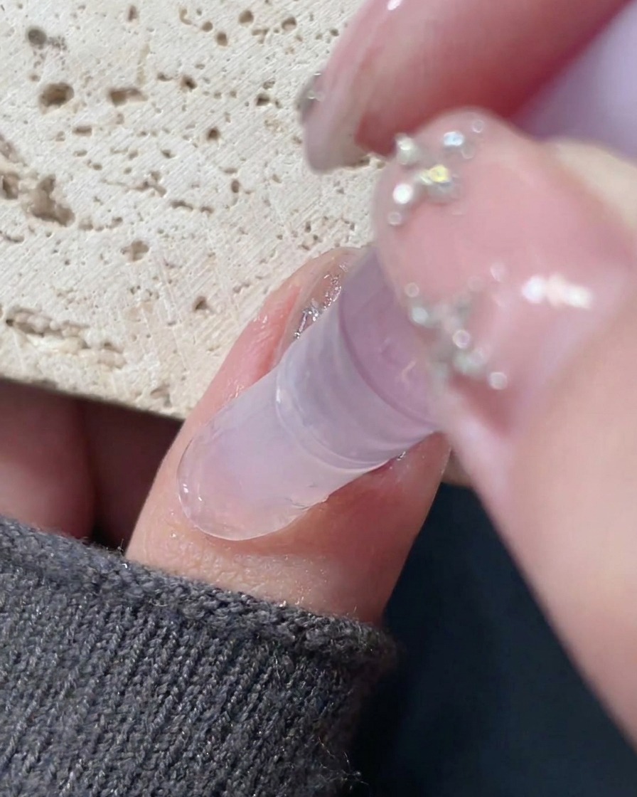 Una penna per olio per cuticole applicata attorno al bordo di ununghia finita per idratare la pelle.