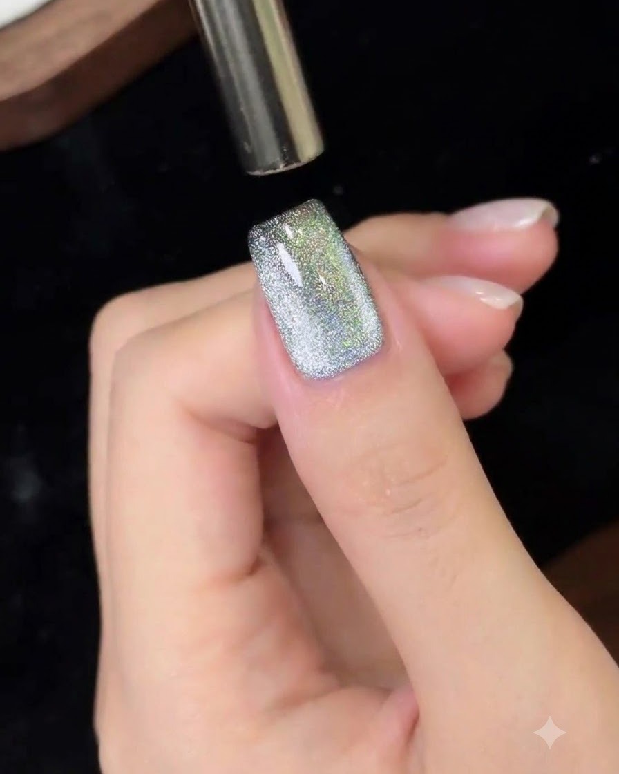 Uno strumento magnetico che viene mosso dallalto verso il basso su ununghia in gel cat eye.