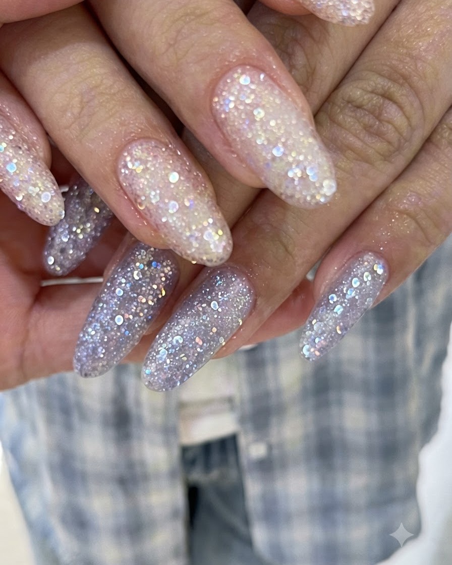 Dita sovrapposte che mostrano lunghe estensioni ricoperte di gel glitterato scintillante rosa e viola.