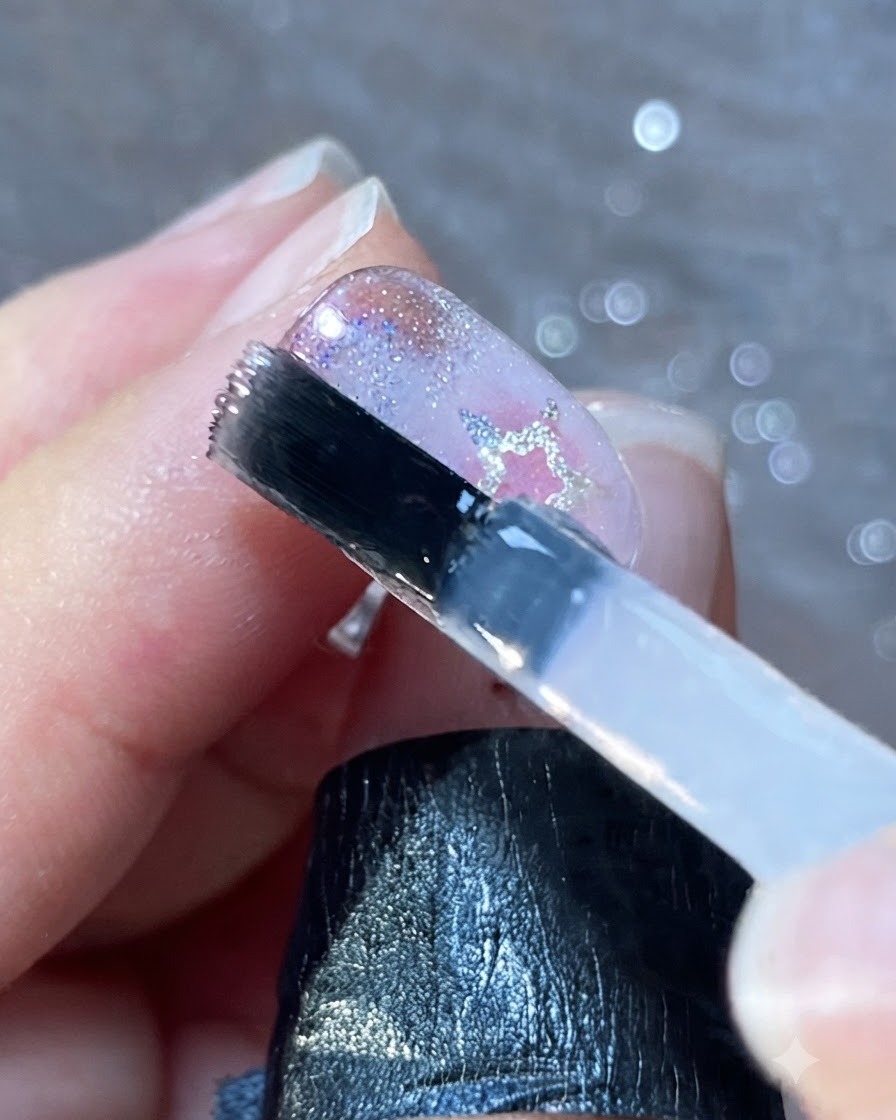 Un pennello per unghie che applica un sottile strato di top coat trasparente sulle unghie decorate.