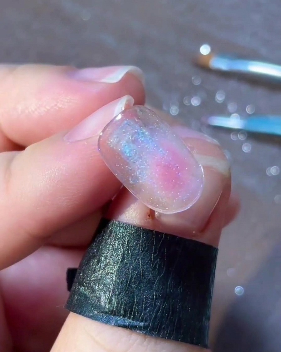 Vista dettagliata di piccoli pois colorati e scaglie disposti delicatamente attorno a un design di nail art con stella argentata.