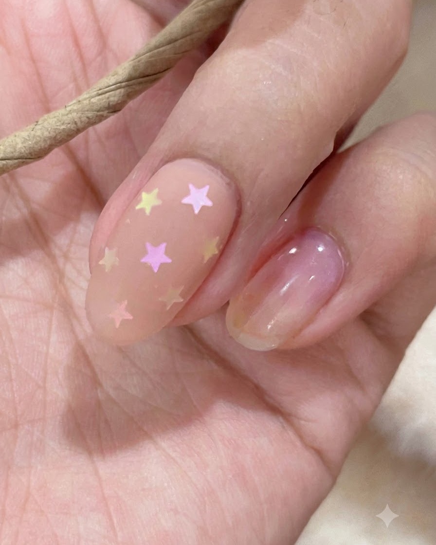 Un primo piano di un bastoncino di campionatura che mostra tonalità di smalto gel nude e rosa.