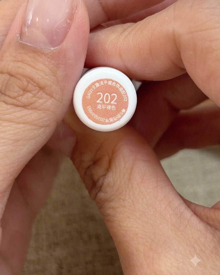 Una vista ravvicinata di mani che tengono la boccetta numero 202 di smalto gel rosa pesca miele.