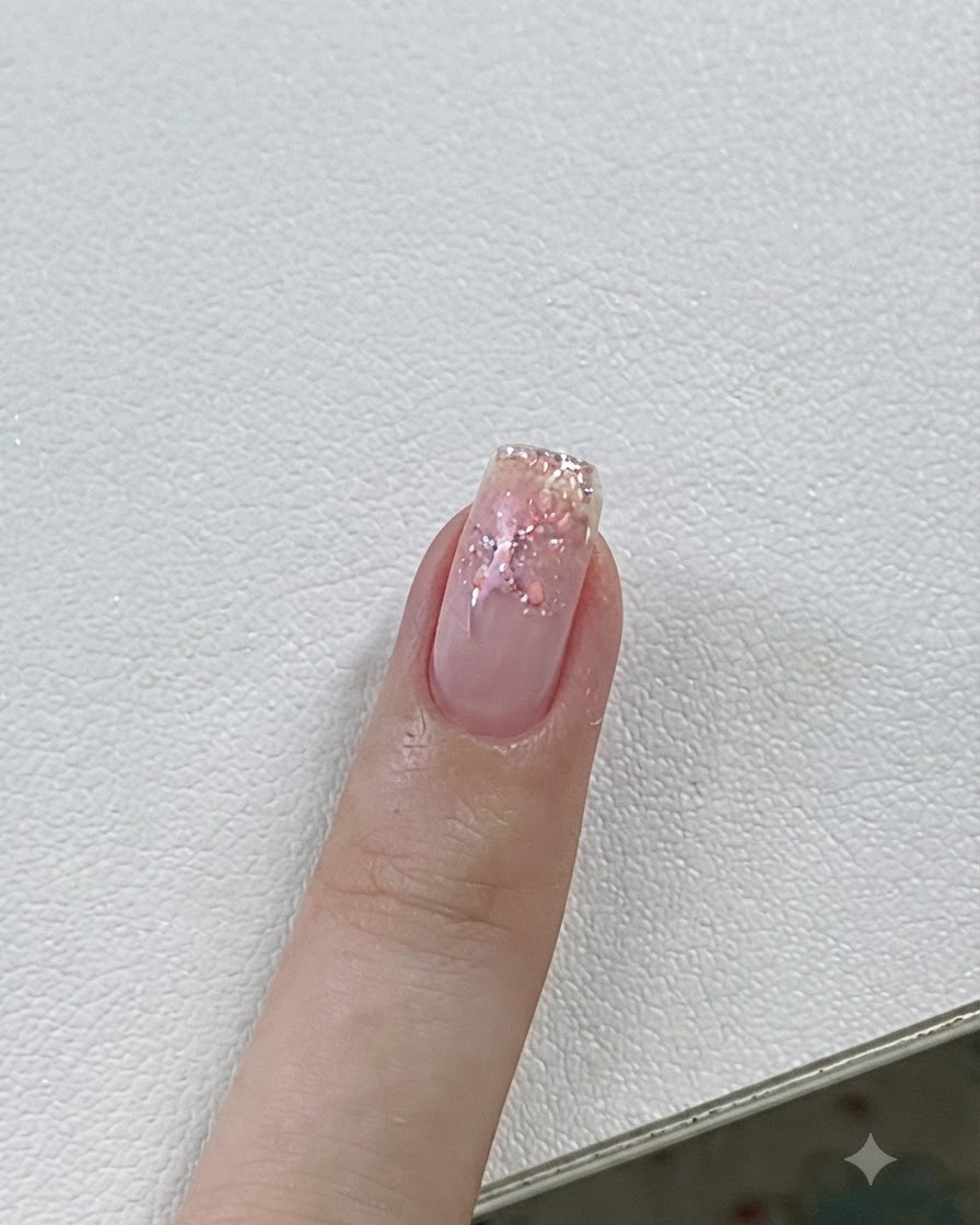 Primo piano di ununghia in fase di polimerizzazione sotto una lampada UV/LED con dettagli in gel rosa e stelle.