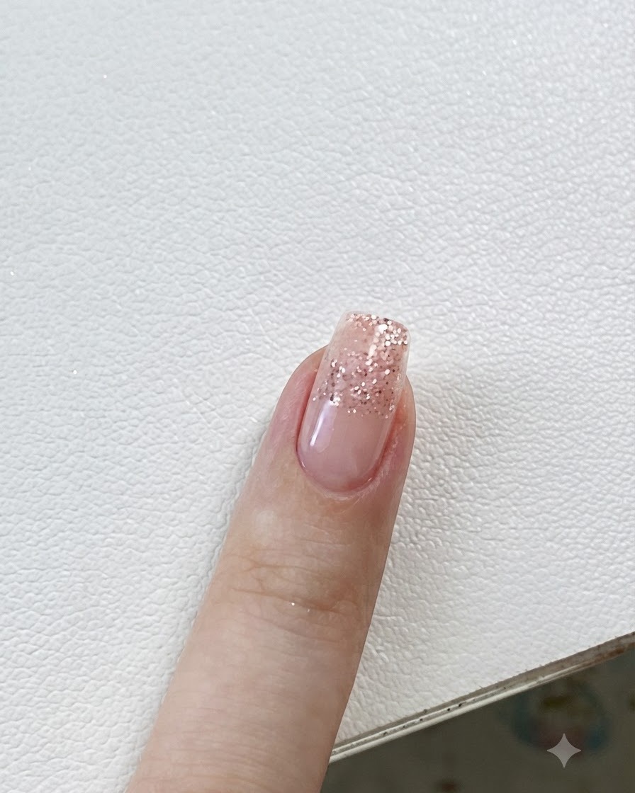 Pinzette che posizionano un piccolo adesivo a stella su unghie con sfumatura glitter.