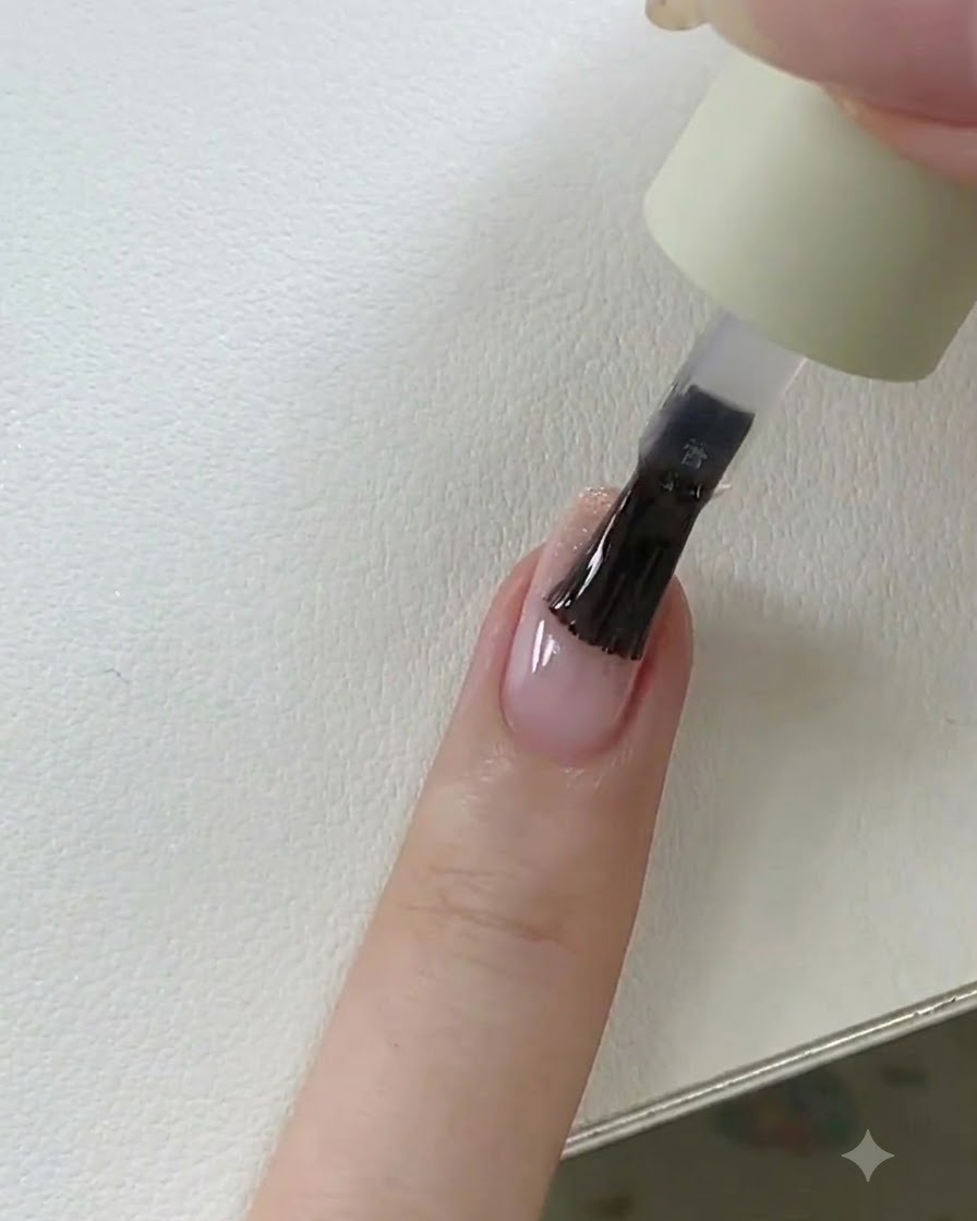 Una mano che posiziona ununghia con top coat bagnato sotto una lampada UV/LED per la polimerizzazione finale.