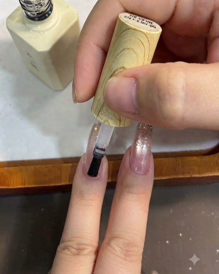Un pennello applica un top coat trasparente su una sfumatura di glitter.