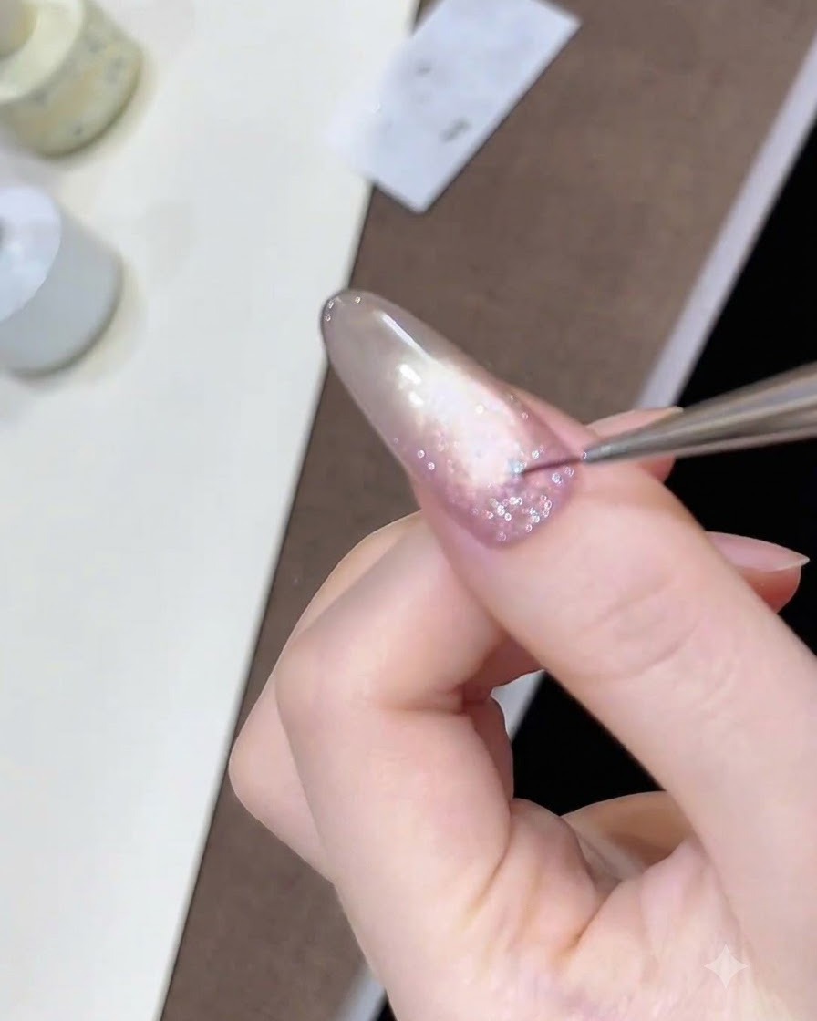Un pennello liner per dettagli fini che posiziona minuscole paillettes a stella sullo strato di gel glitter bagnato.