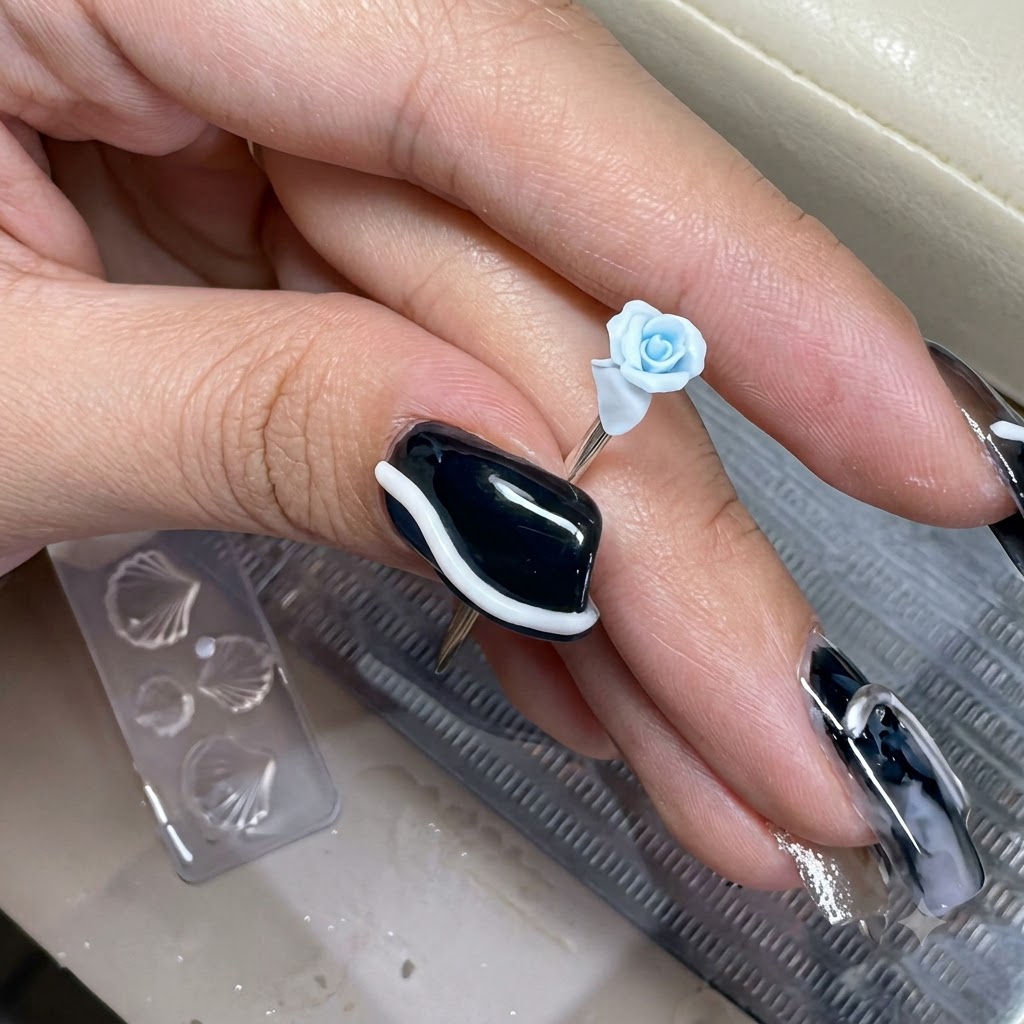 Un minuscolo petalo di argilla azzurra che viene posizionato sul bordo esterno di una rosa in miniatura scolpita.