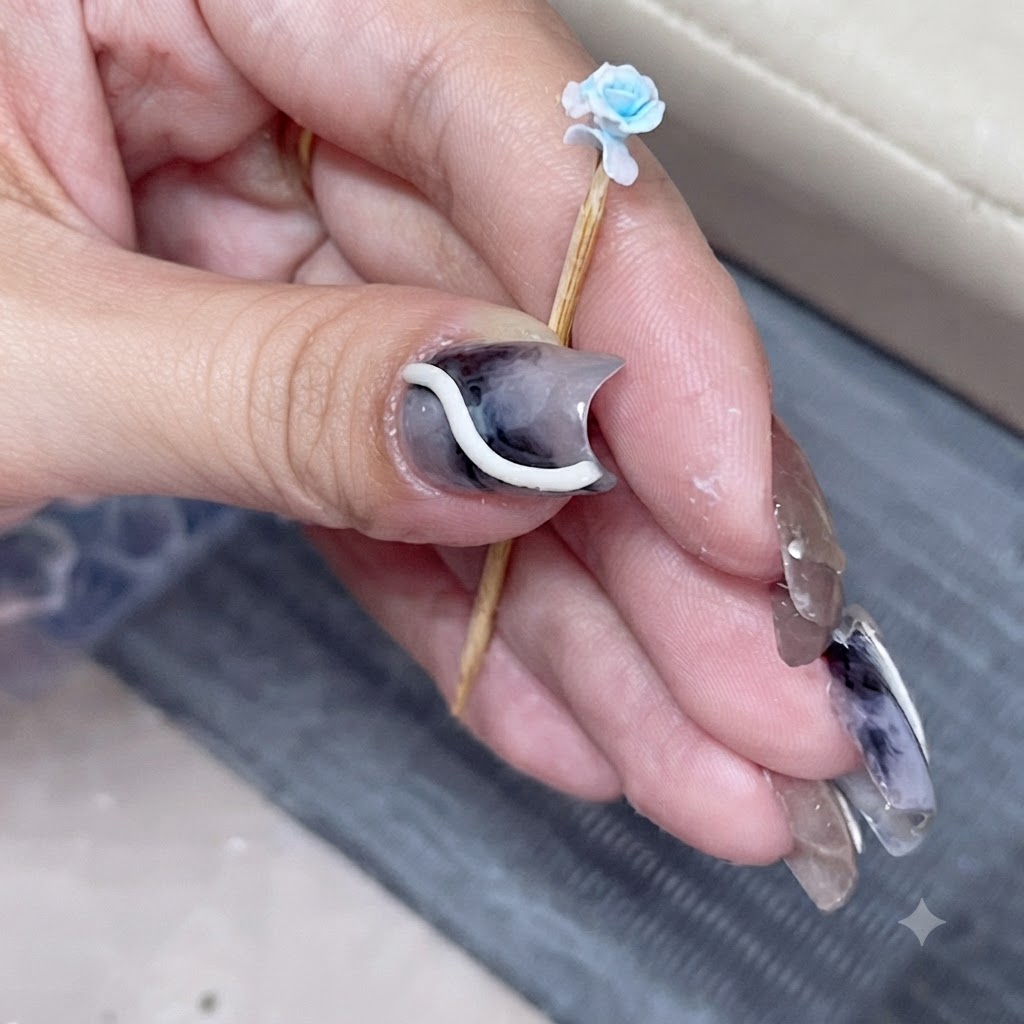 Un primo piano di una rosa blu in miniatura su uno stecchino con un petalo sovrapposto appena attaccato.