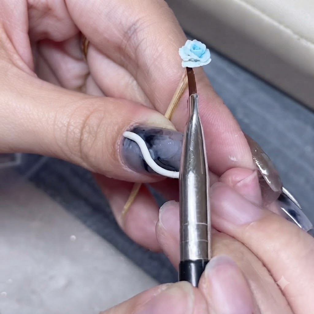 Uno strumento metallico appuntito che preme delicate arricciature sul bordo di una rosa in argilla blu.