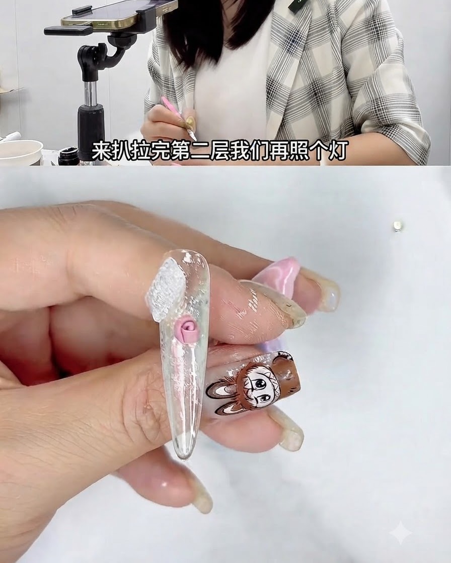 Una mano che tiene ununghia sotto una piccola lampada di polimerizzazione UV durante un tutorial di nail art 3D.