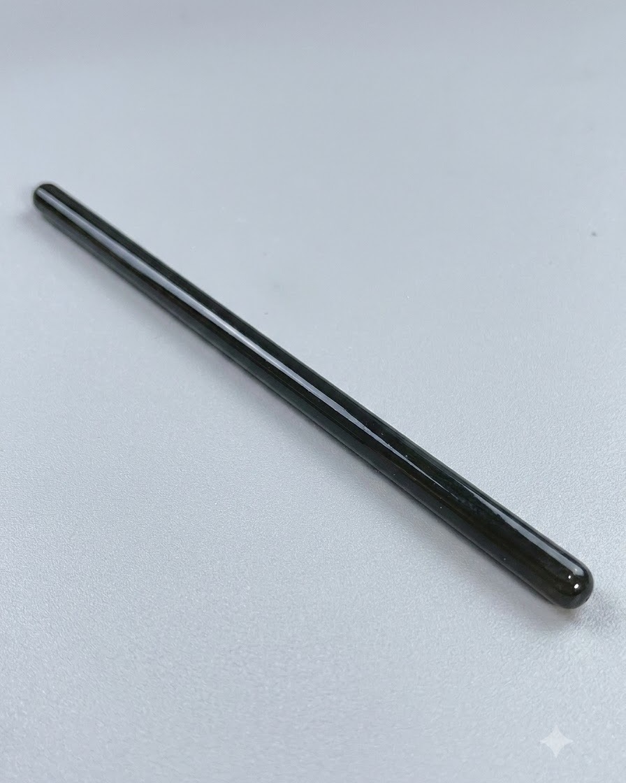 Un pennello da nail art a punta fine e lunga appoggiato su una superficie pulita prima del lavoro di precisione.