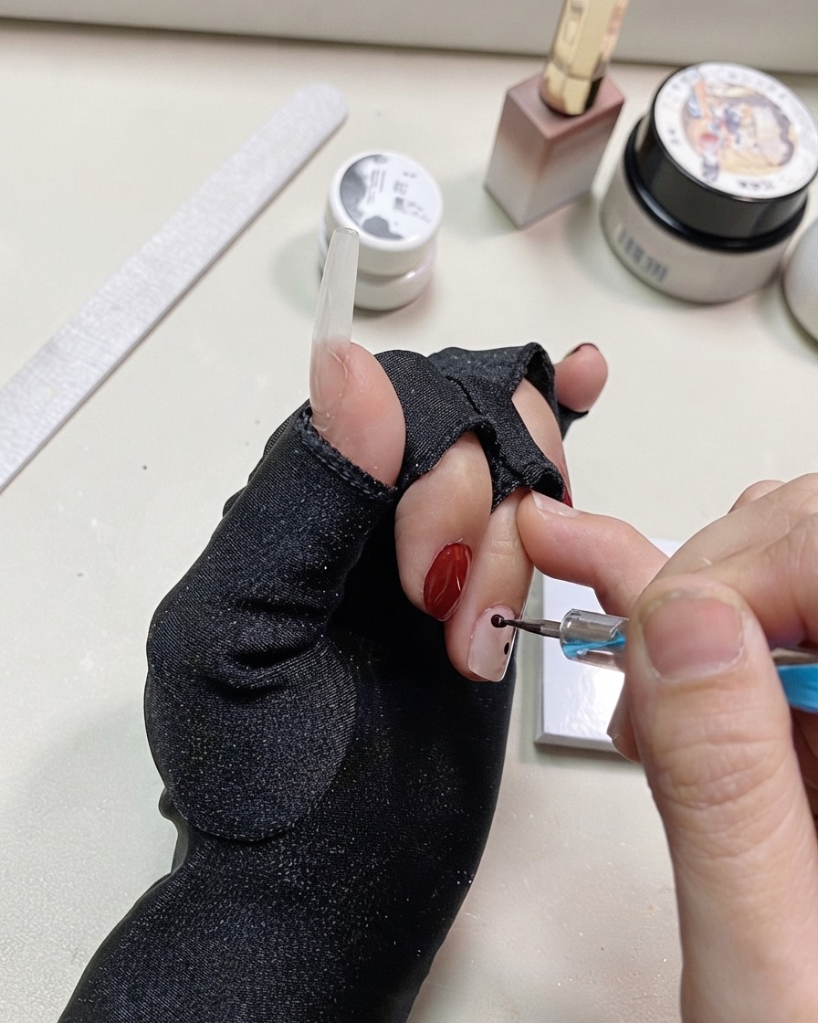Un dotting pen che aggiunge altri punti neri vicino ai precedenti sullunghia.