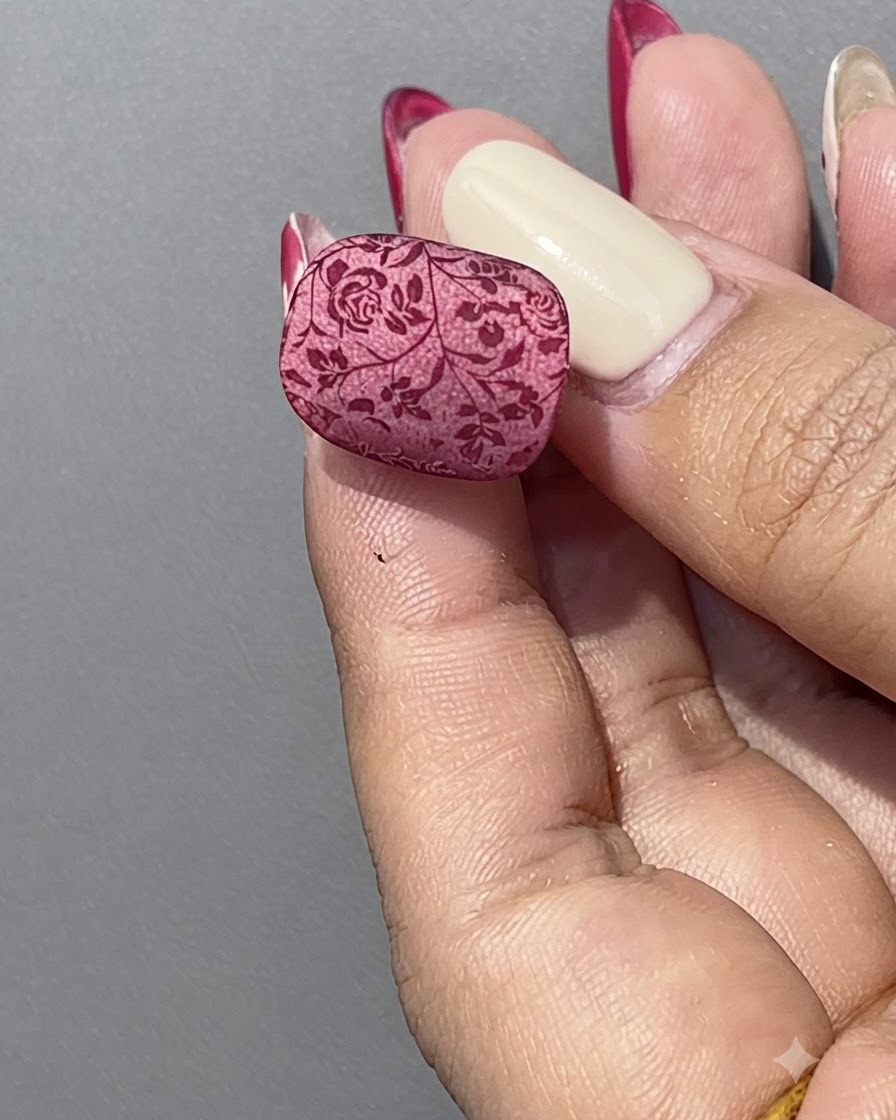 Una mano che tiene una boccetta di gel cat eye rosso accanto a un espositore trasparente per unghie.