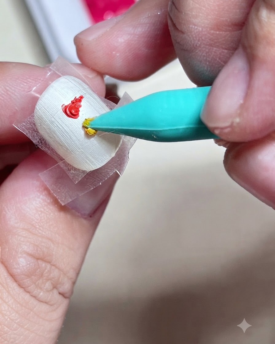 Primo piano di uno strumento in silicone che applica una goccia di gel colorato giallo direttamente sotto un tocco rosso allinterno di un quadrato incerottato su ununghia.