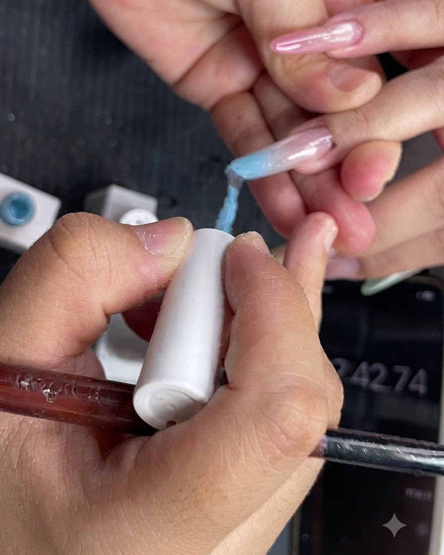 Una vista ravvicinata del gel polish azzurro applicato sulla metà superiore di ununghia.