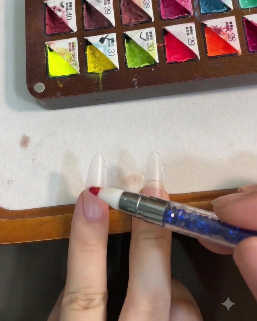 Uno strumento in silicone che picchietta il gel rosa al centro di ununghia per formare un effetto blush.