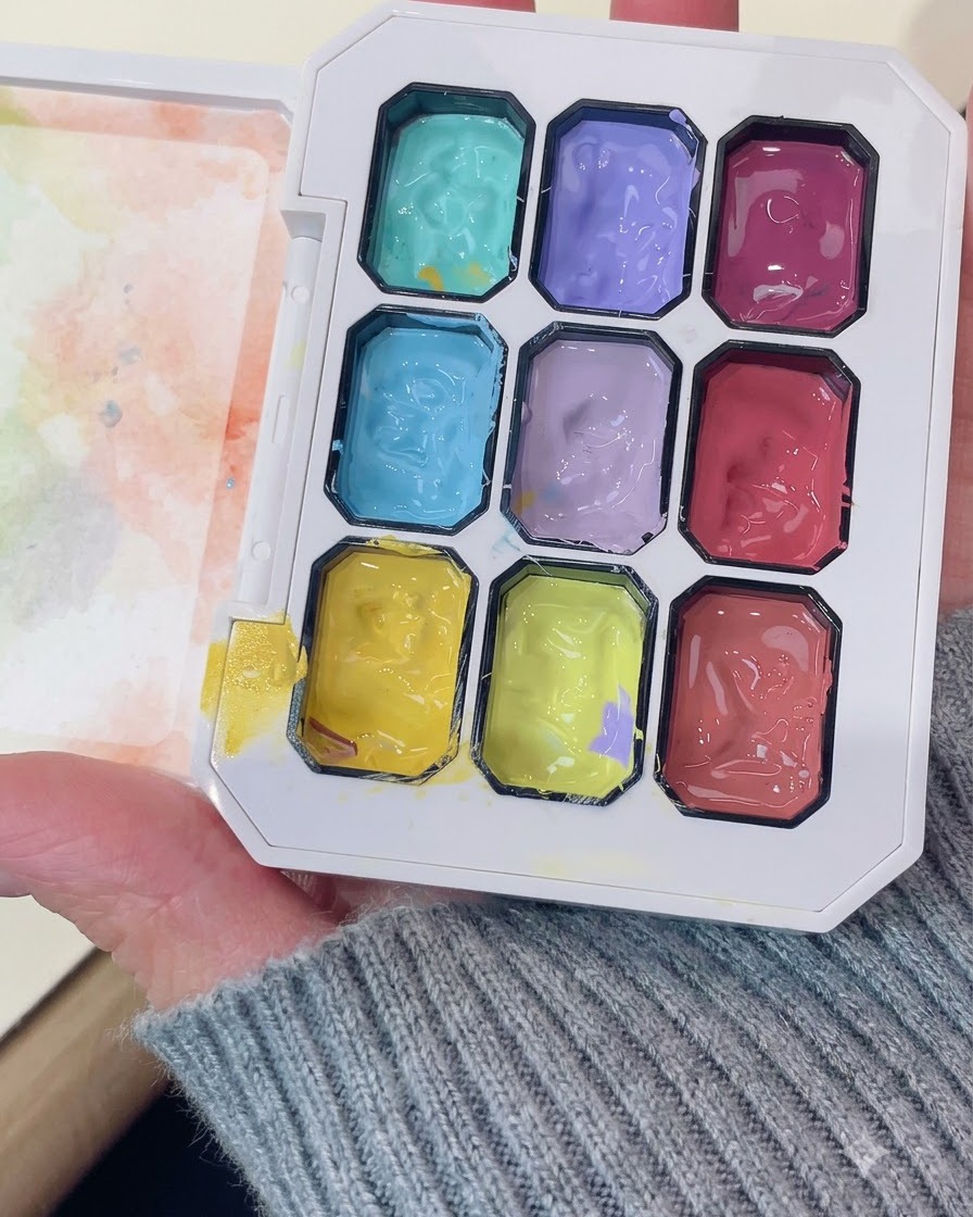 Una tavolozza di gel professionale che mostra scomparti di gel viola brillante e di altri colori.
