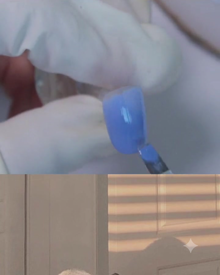 Un pennello per gel piatto che applica uno strato di gel blu-viola sulla superficie di ununghia.