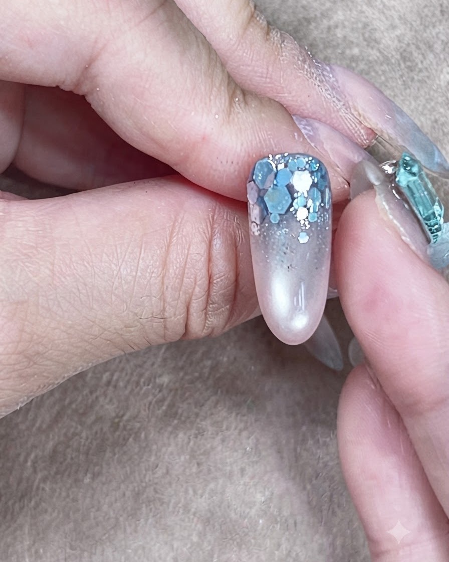 Una struttura ungueale completata con gel costruttore trasparente autolivellato che racchiude la nail art glitterata.