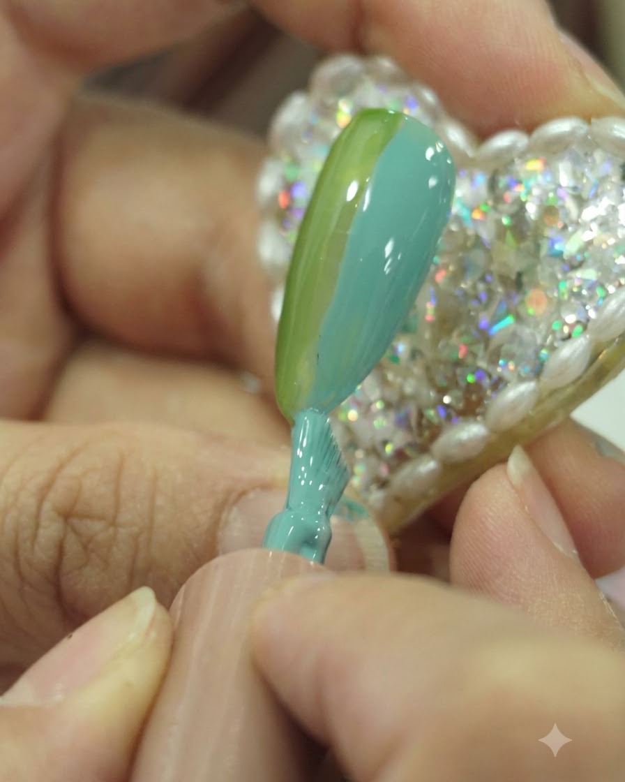 Primo piano di un pennello da unghie che applica lo smalto gel teal proprio accanto alla sezione verde sulla superficie dellunghia.