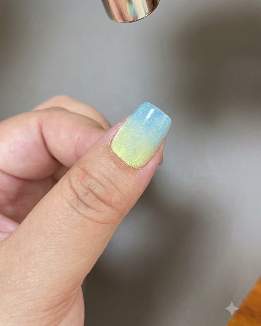 Uno strumento magnetico che modella unampia striscia di luce su ununghia rivestita di gel scintillante.