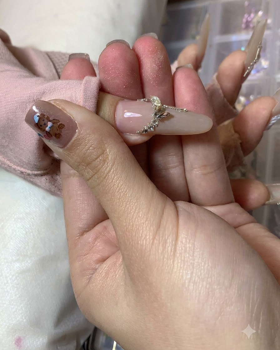 Una nail artist aggiunge gli ultimi tocchi bianchi lungo i bordi esterni della nail art a farfalla completata.