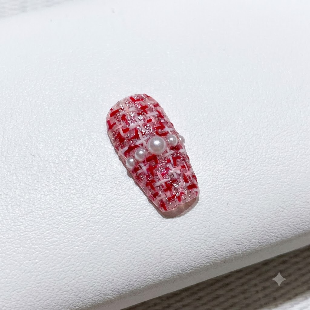 Un pennellino sottile che riempie con smalto gel rosso acceso un lato di una french a V.