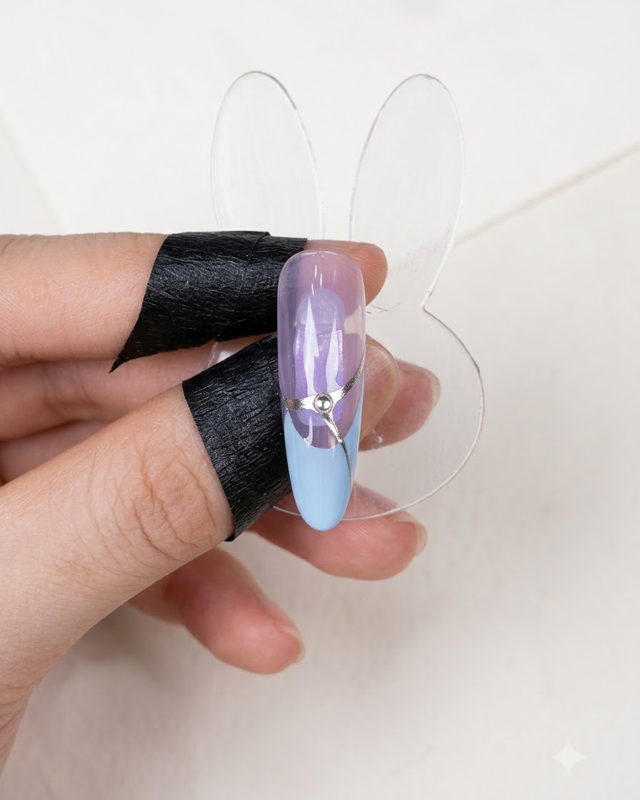 Un display per unghie finito che mostra un design di manicure French completato con una linea daccento argentata e uno strass centrale.