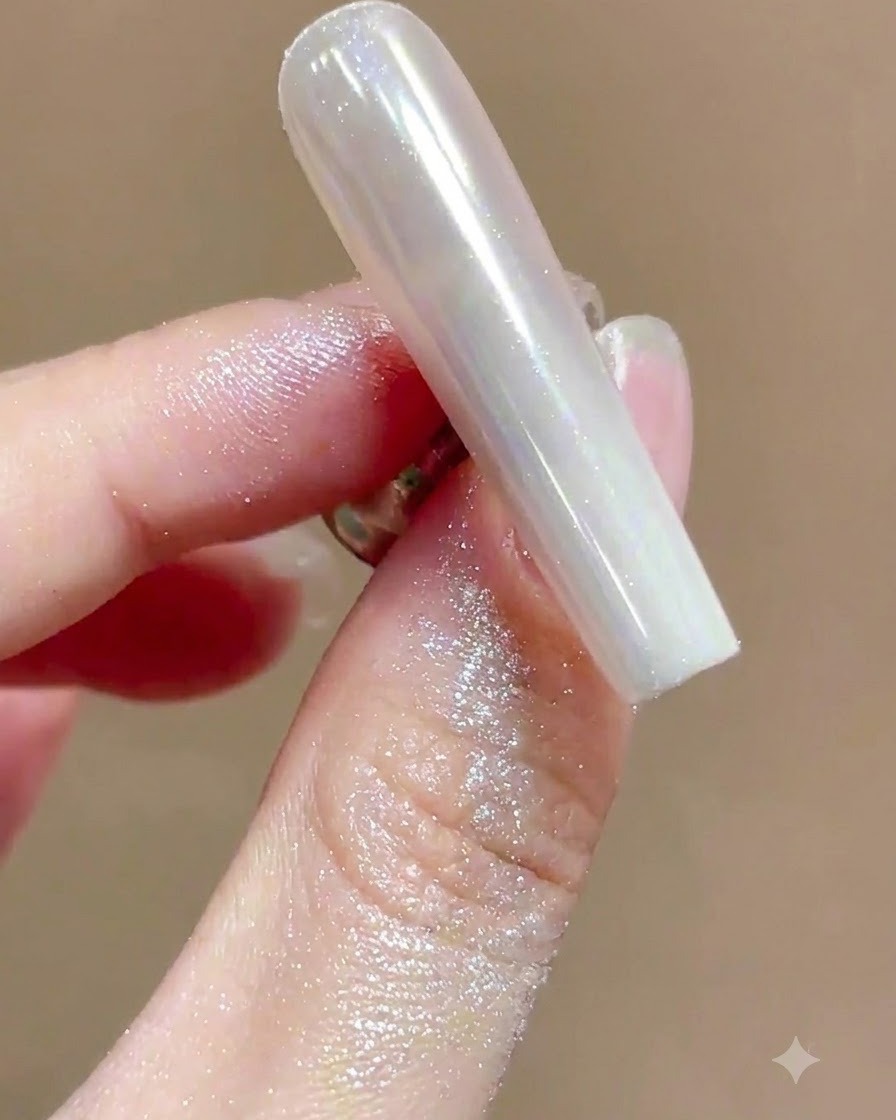 Un pennello morbido che spazza via la polvere brillante in eccesso da ununghia manicure chrome ad alta lucentezza.