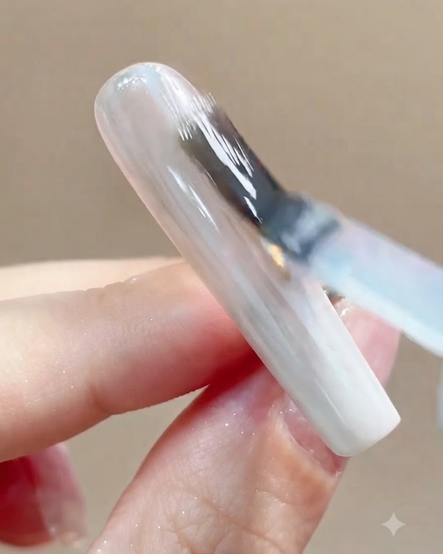 Primo piano di ununghia inserita sotto una lampada di polimerizzazione UV o LED dopo lapplicazione del top coat.