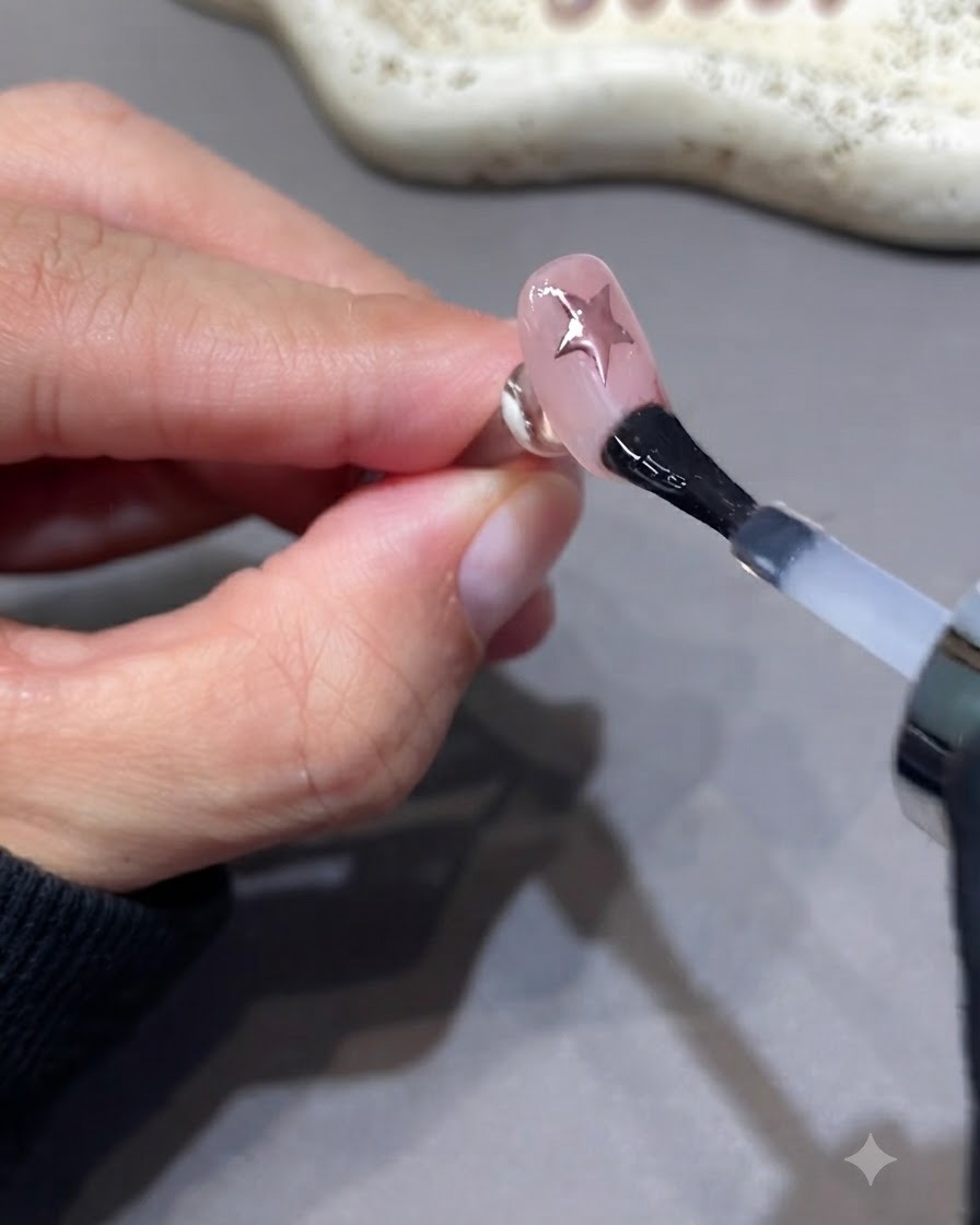 Un pennello che applica un ulteriore strato di top coat sigillante su ununghia curata.