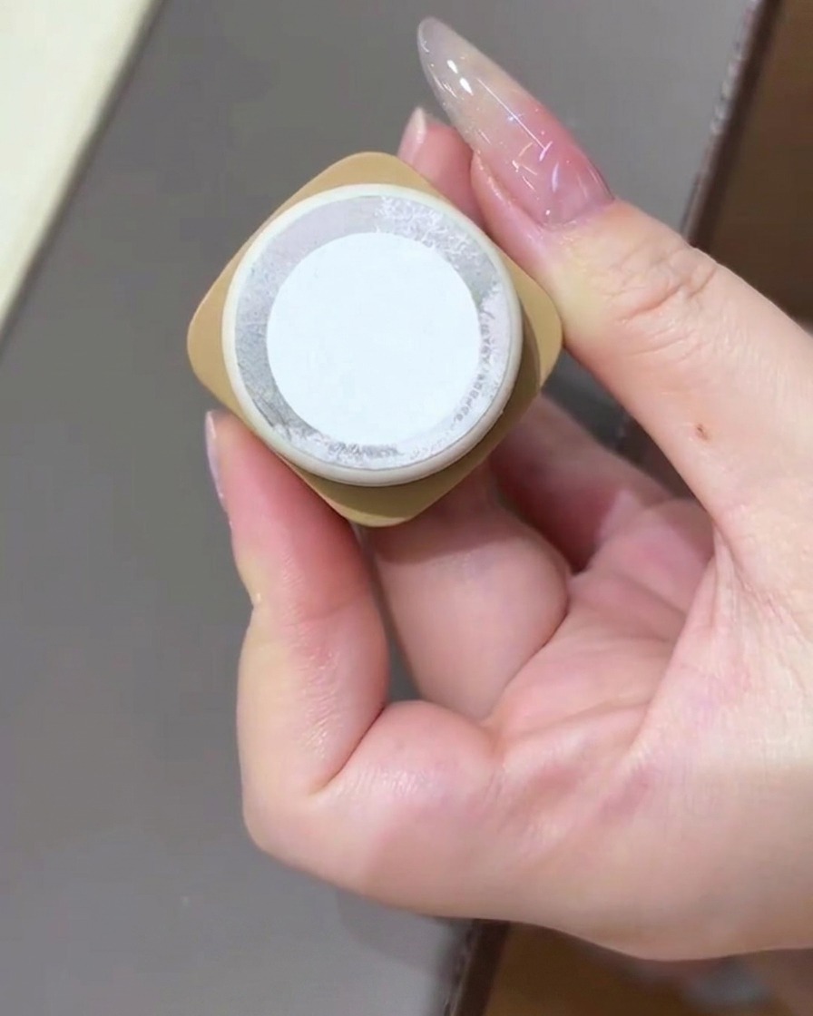 Una mano che regge una boccetta di gel cat-eye rivolta verso la camera.