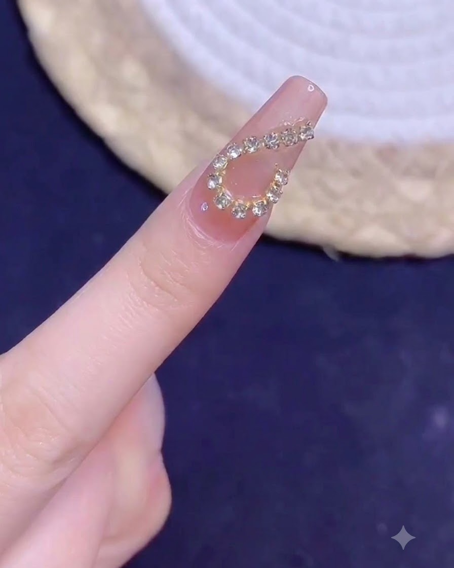 Un dito con manicure con un design a cuore con catenella dorata mostrato in primo piano sotto la luce dopo la polimerizzazione.