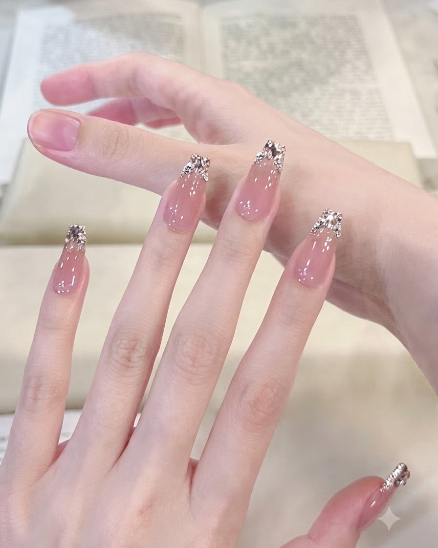 Scatto macro focalizzato su pollice e indice con manicure che evidenzia la dettagliata sfumatura di glitter argento e le gemme di cristallo disposte.