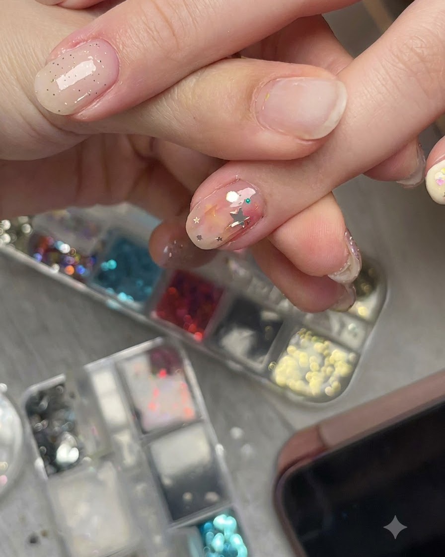 Uno scatto in primo piano di una mano che mostra un pezzo di glitter a stella pre-curvato su ununghia da unangolazione laterale per mostrare la sua aderenza a filo.