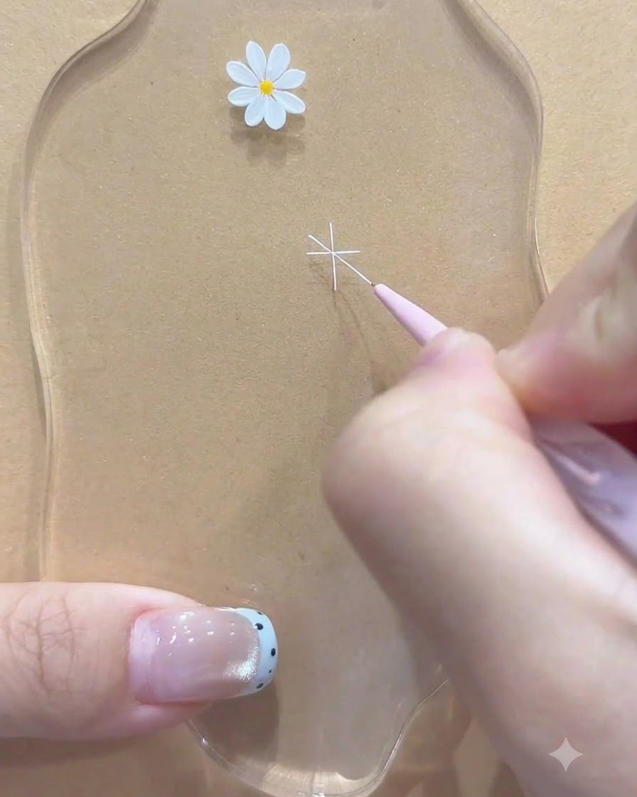 Un pennello a punta fine che aggiunge ulteriori linee bianche diagonali per completare il contorno del fiore di margherita.