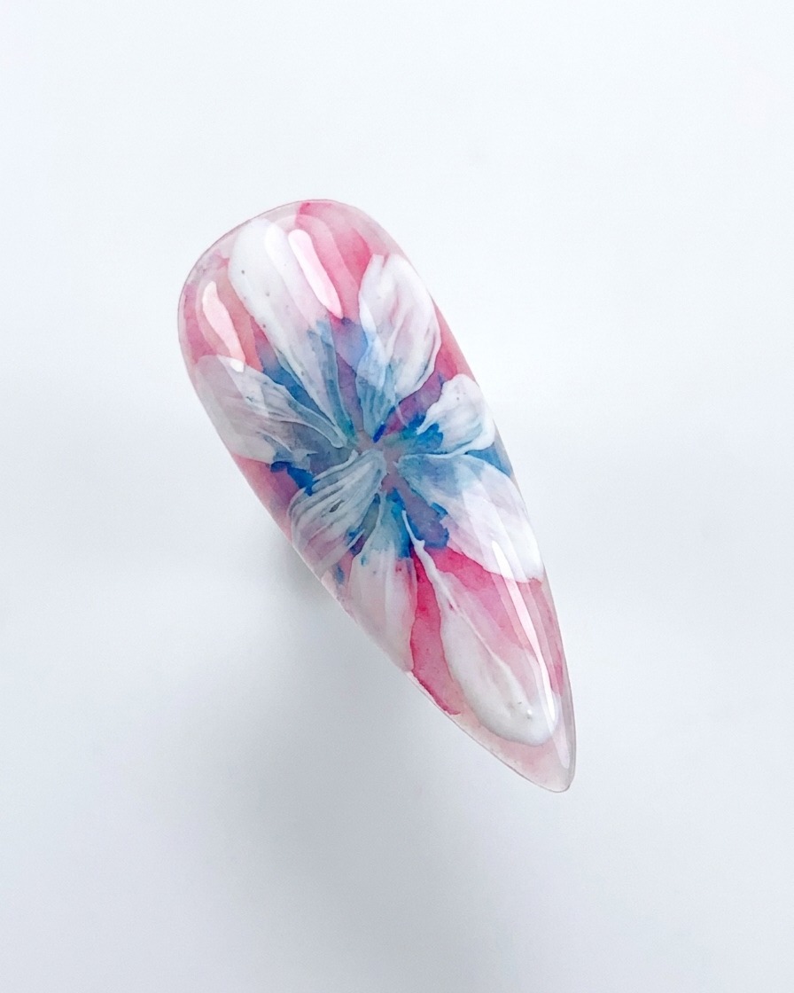 Una mano che posiziona ununghia decorata sotto una lampada di polimerizzazione UV/LED rosa.