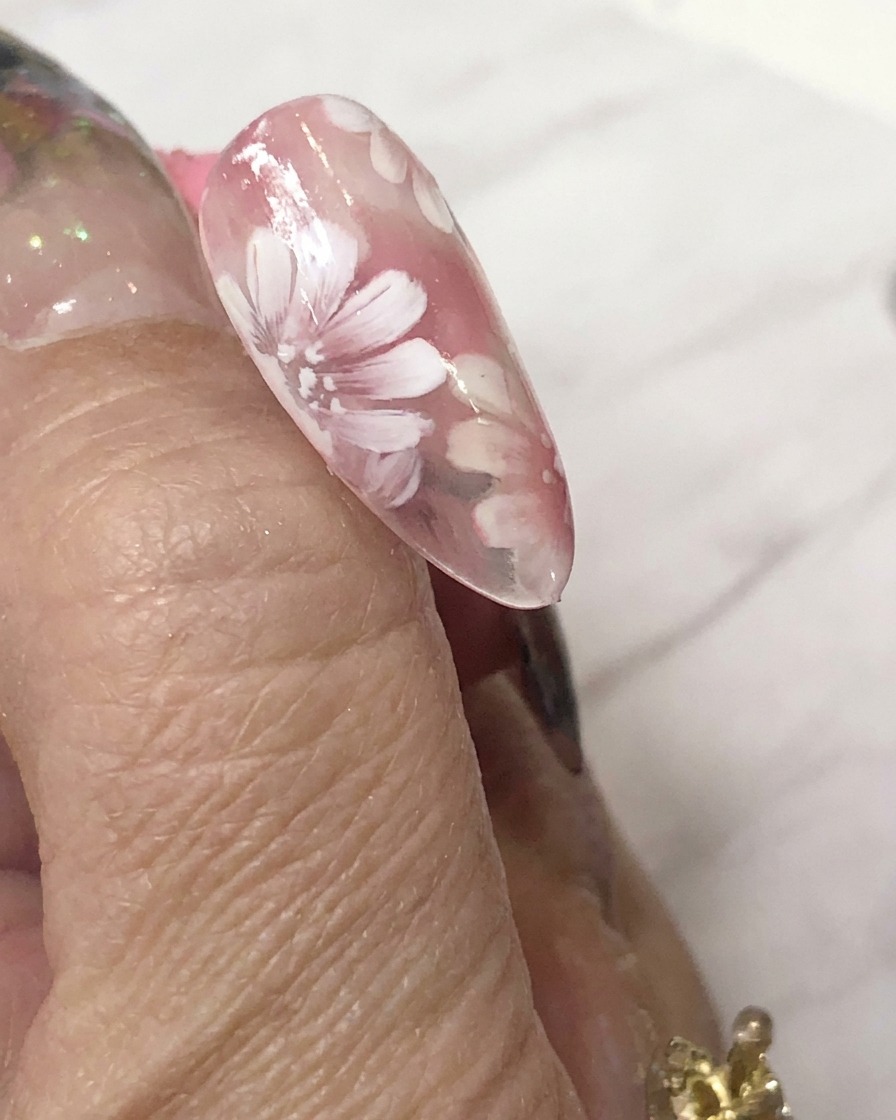 Una mini lampada di polimerizzazione a LED posizionata direttamente sopra ununghia decorata per polimerizzare la nail art in gel.