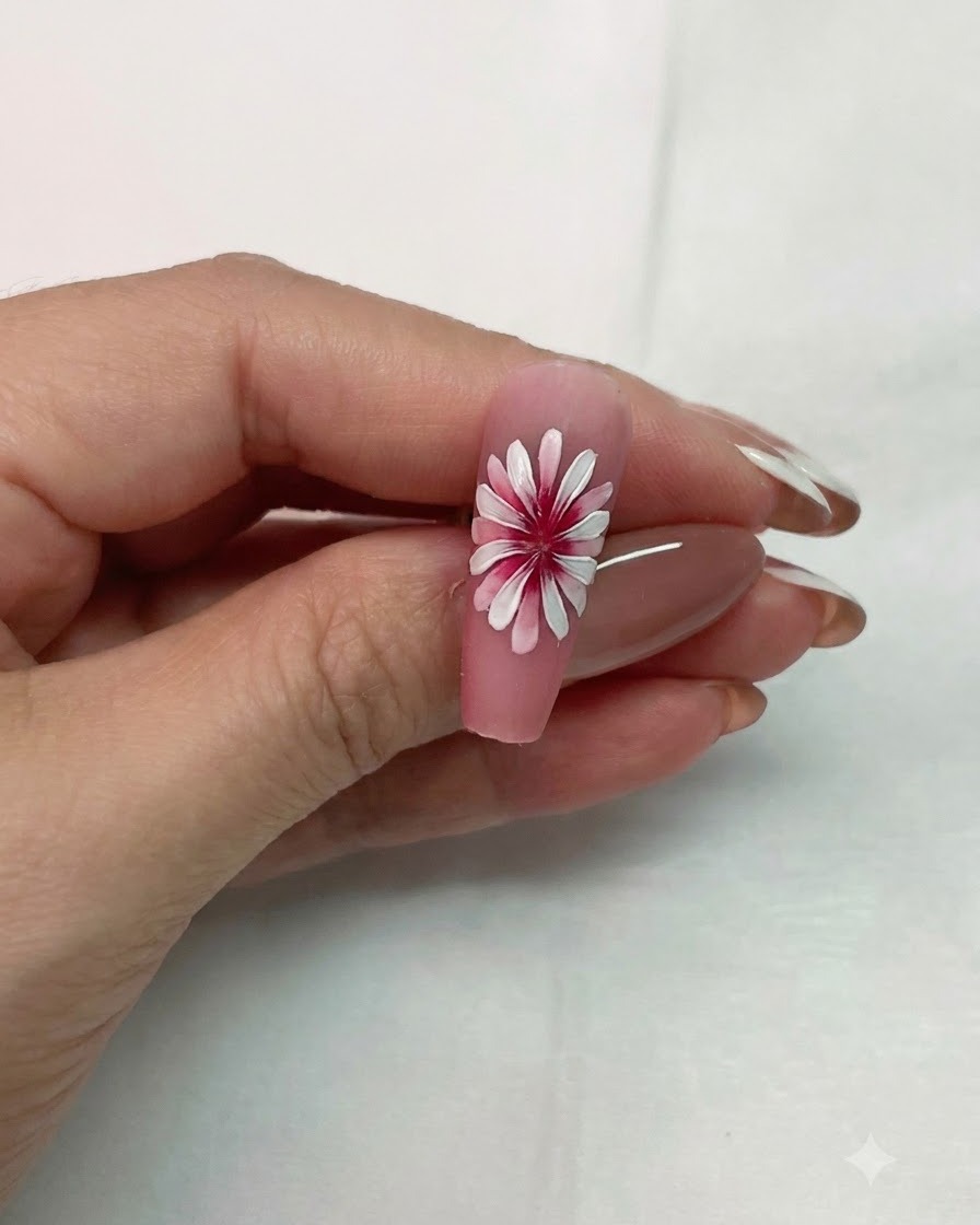 Un design di nail art con margherita bianca a doppio strato completato tenuto in alto per mostrare leffetto 3D dimensionale.